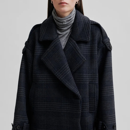 dark grey check jacket with wide collar and straps on cuffs and shoulders