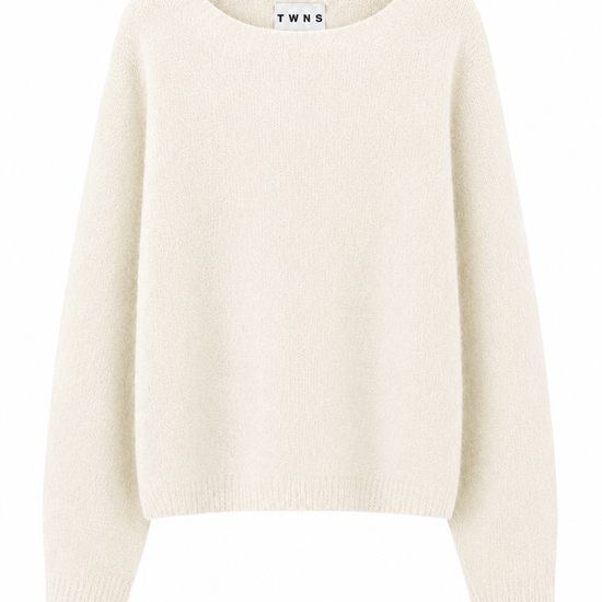A cream-colored knit sweater with long sleeves and a crew neck, shown against a plain white background. The brand name 'TWNS' is visible on the inner neck label.