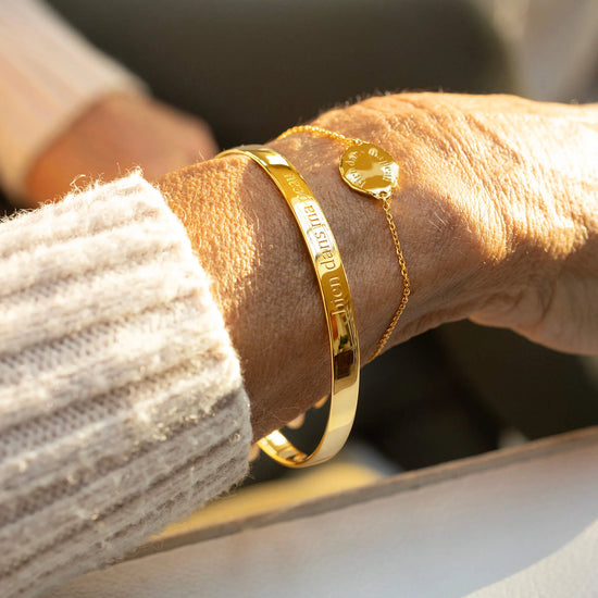 Gold bracelet on a wrist with a blurred background