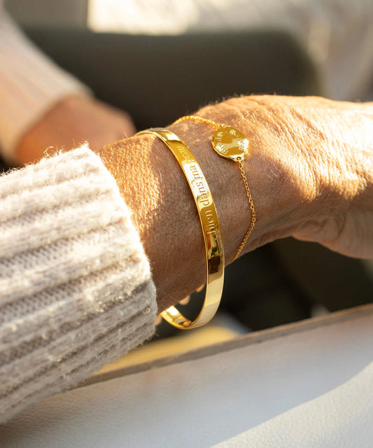 Gold bracelet on a wrist with a blurred background