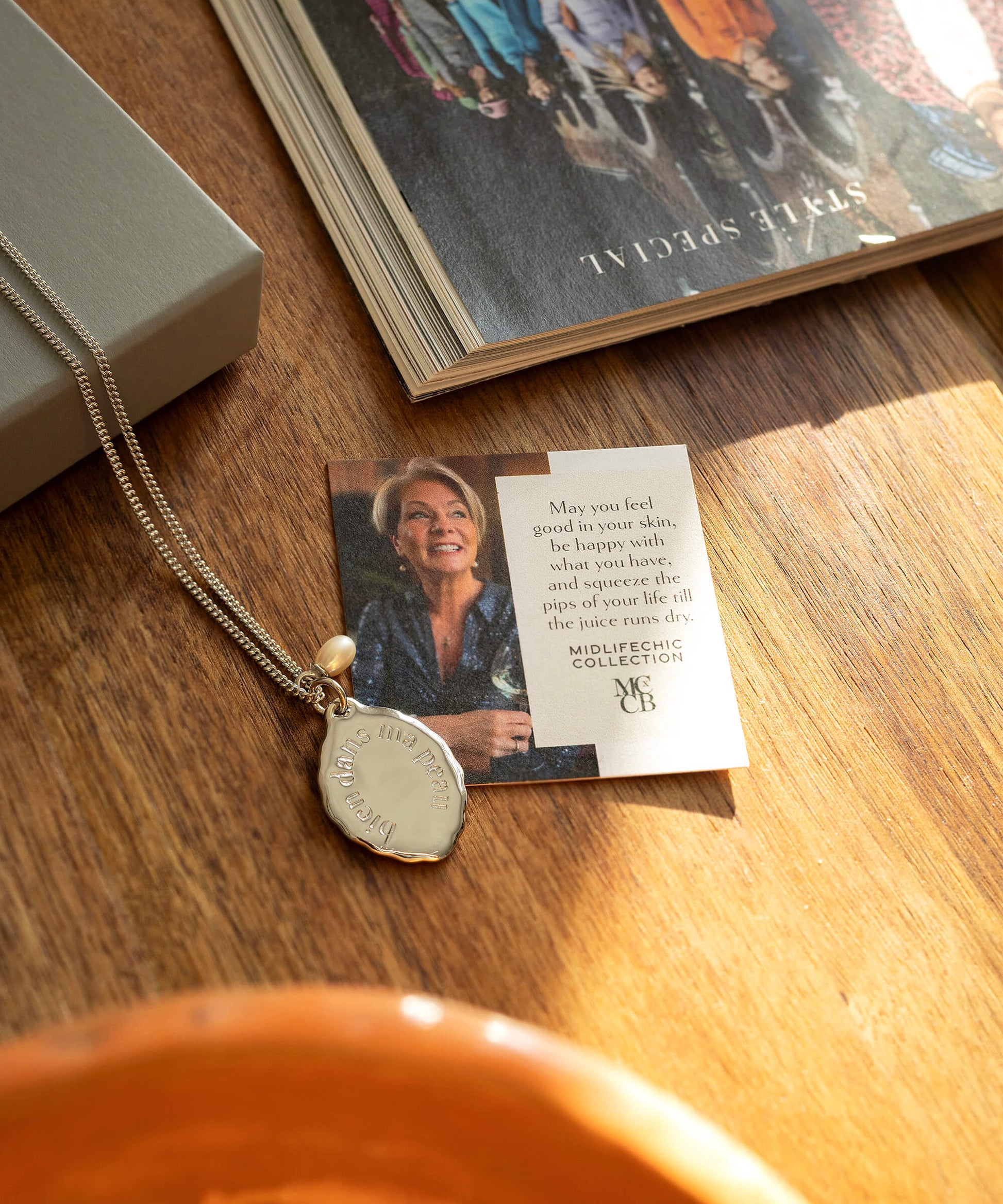 Necklace with pendant and card on a wooden surface