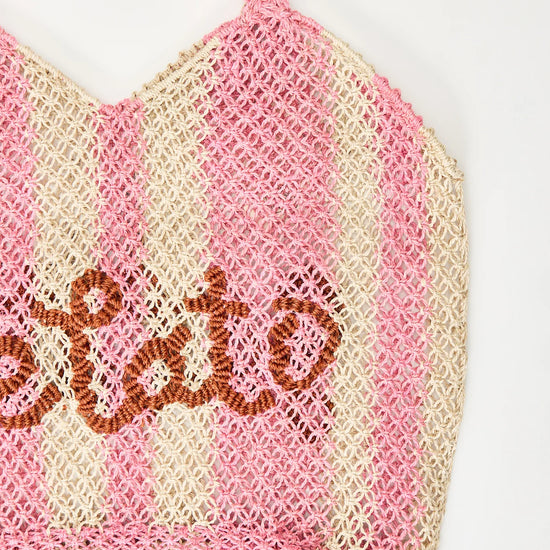 pink and white straw bag with slogan on white background zoomed in