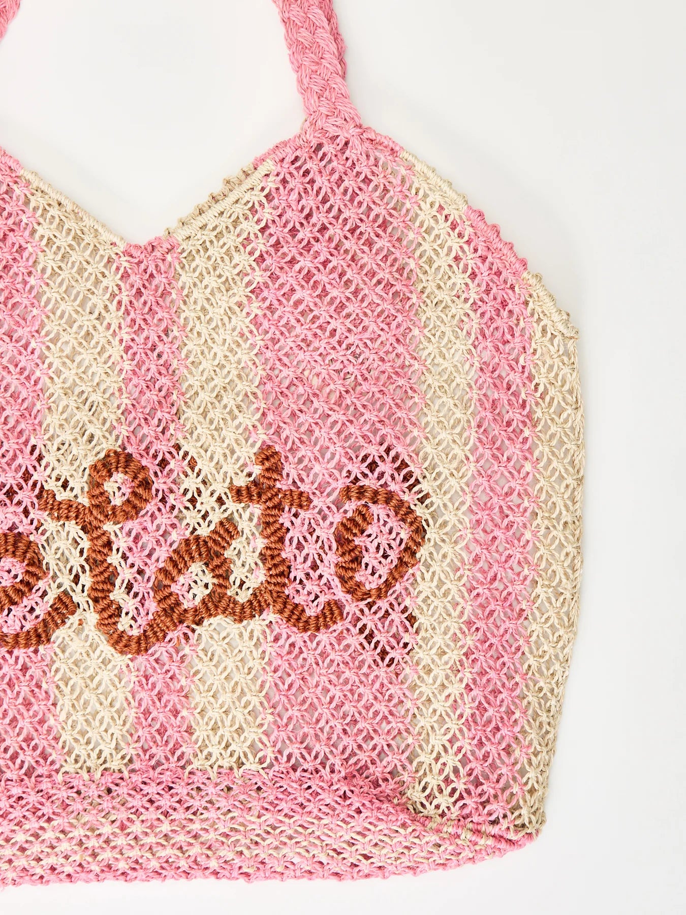 pink and white straw bag with slogan on white background zoomed in