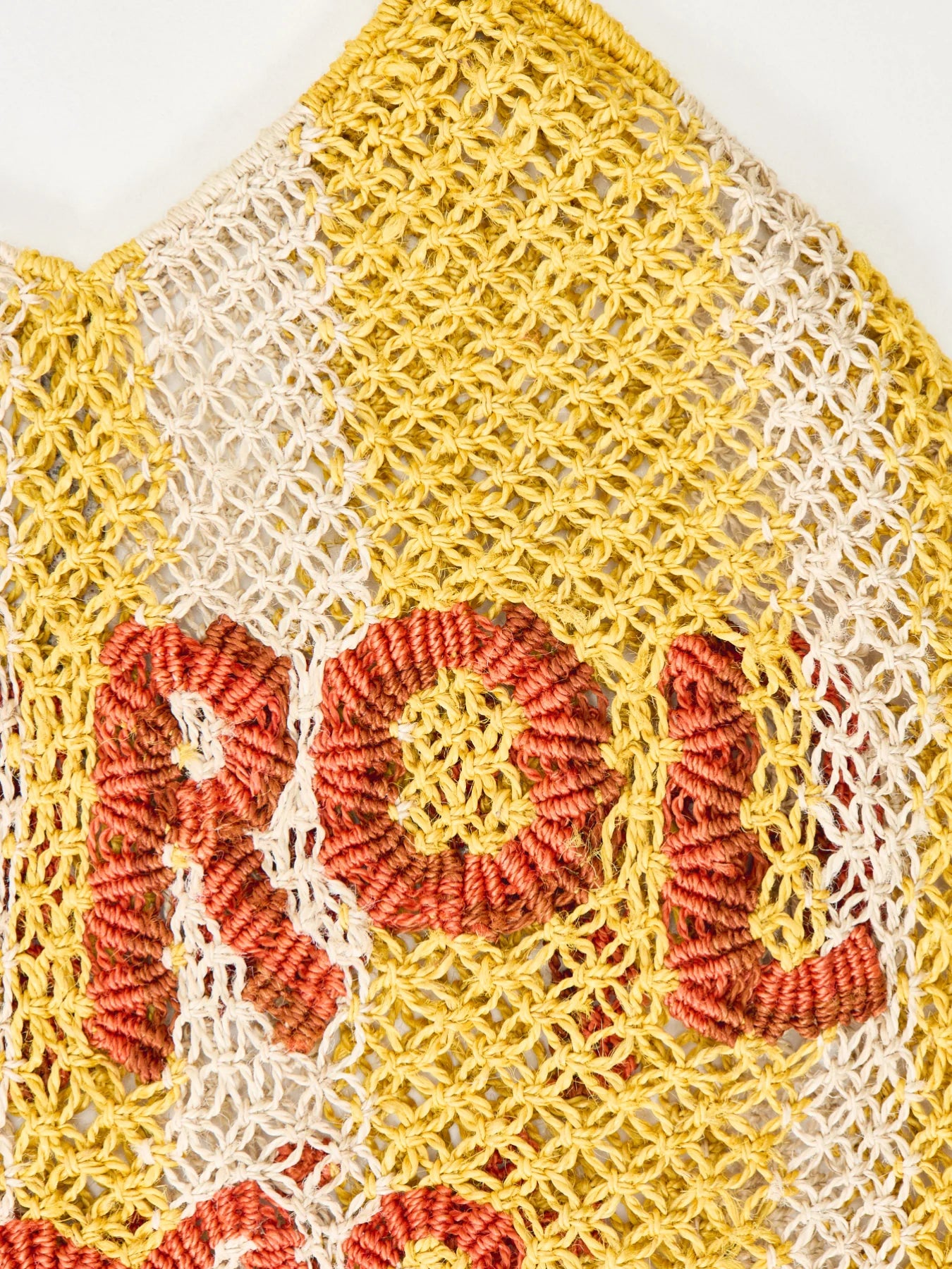 yellow stripe straw bag with slogan on white background zoomed in