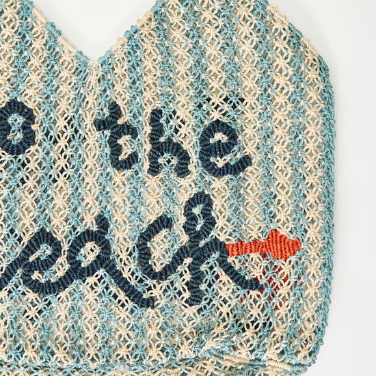 white and blue stripe straw bag with slogan on a white background
