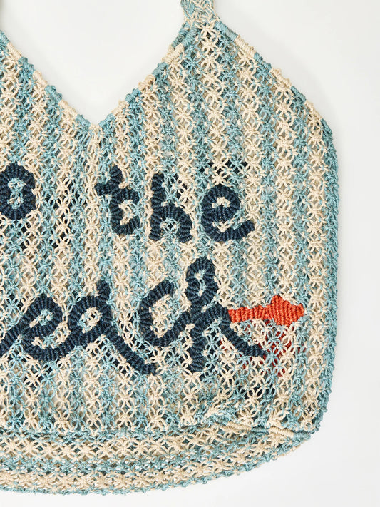 white and blue stripe straw bag with slogan on a white background

