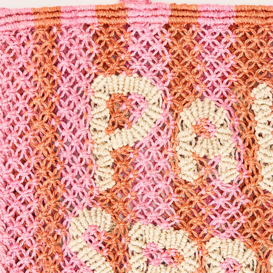 pink and orange string bag with slogan on a white background zoomed in