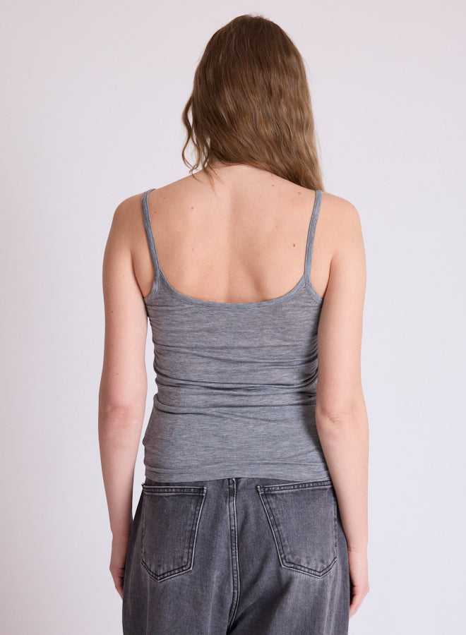 A woman shown from the back wearing a heather gray ribbed tank top and dark gray jeans against a plain light gray studio background.
