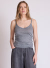 A woman modeling a heather gray ribbed tank top with wide-leg gray denim pants, standing against a plain light gray studio background.