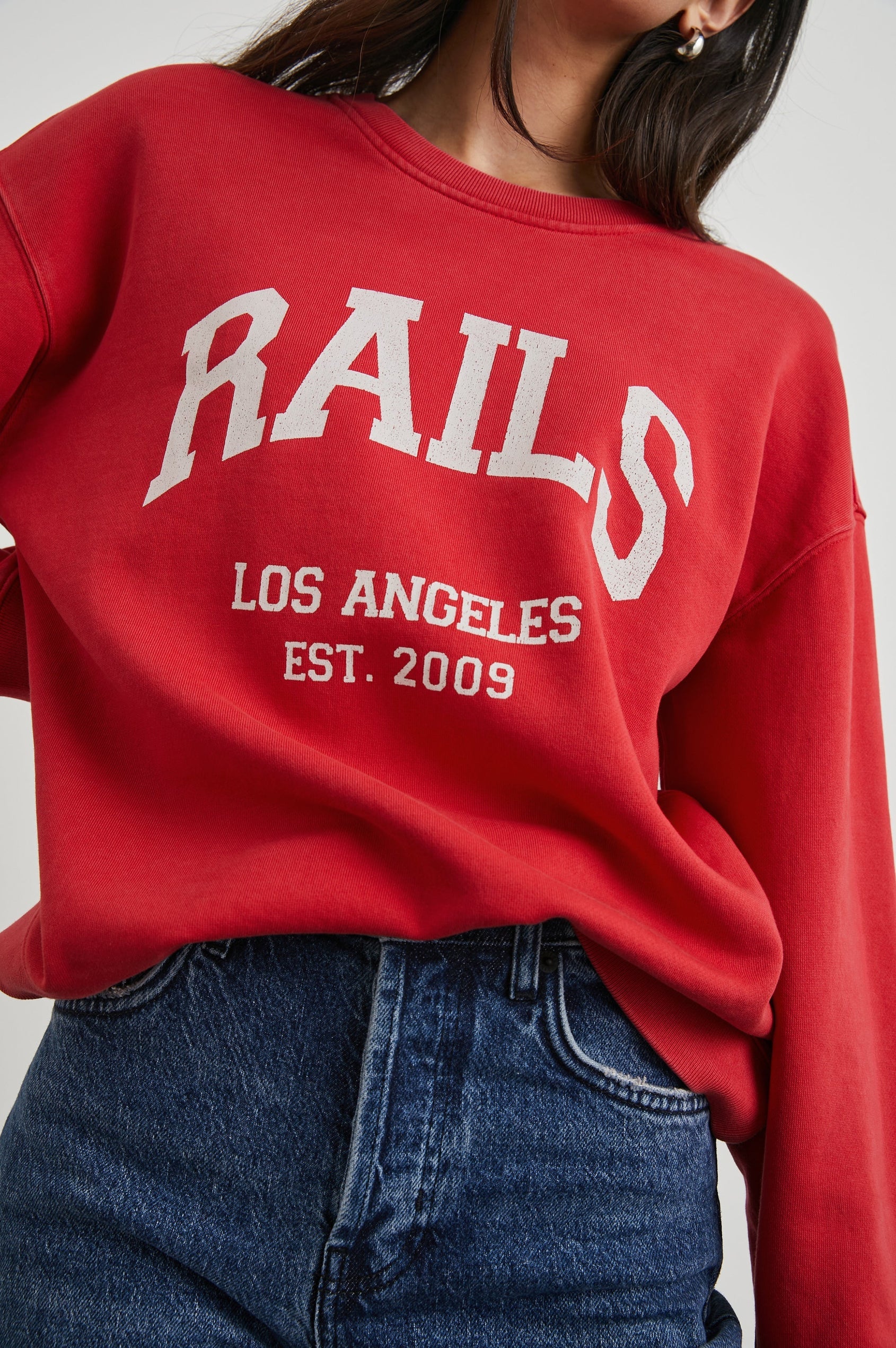 Washed red cotton swearshirt with white rails logo across the chest