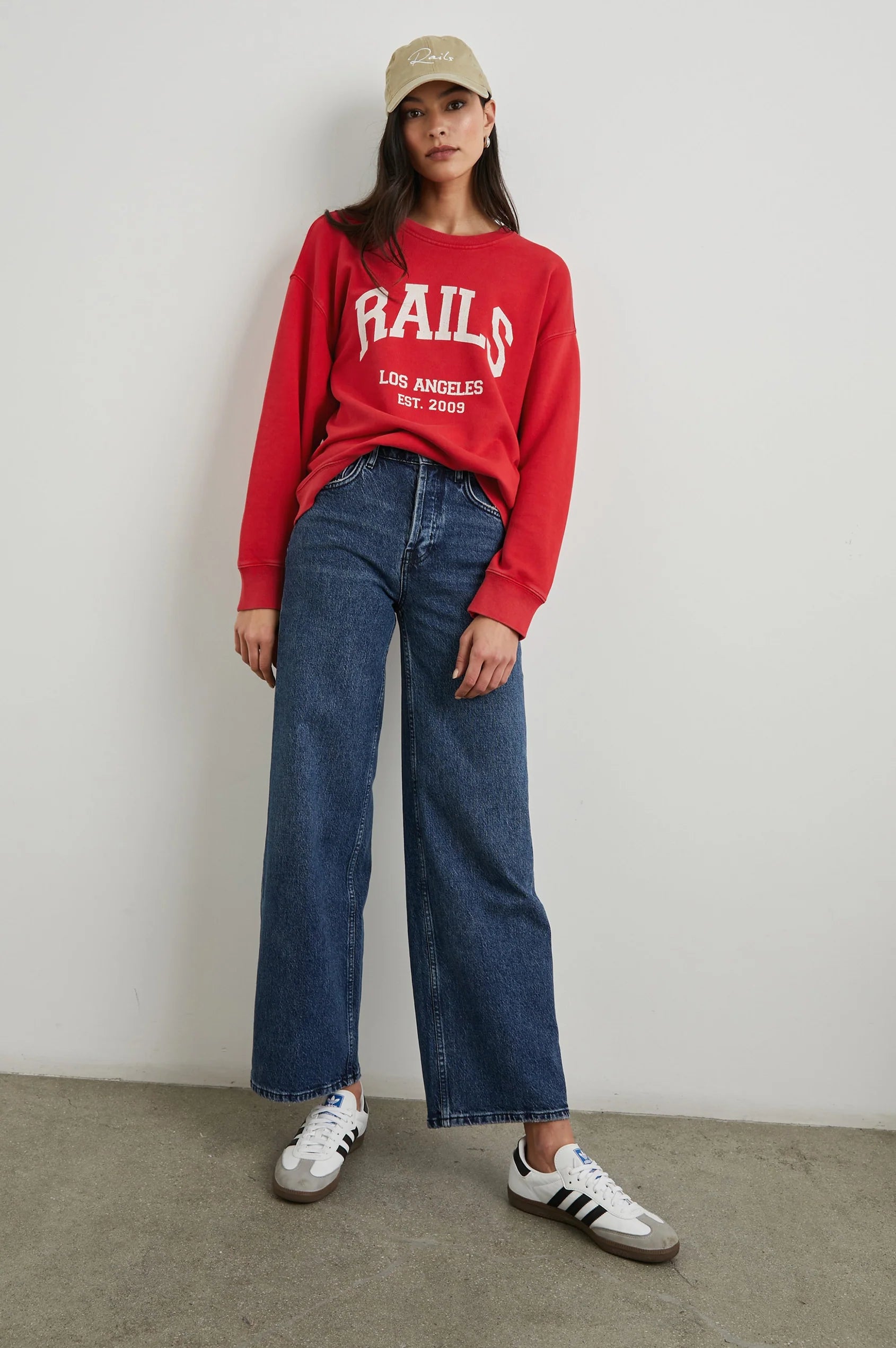 Red sweatshirt with blue jeans on model