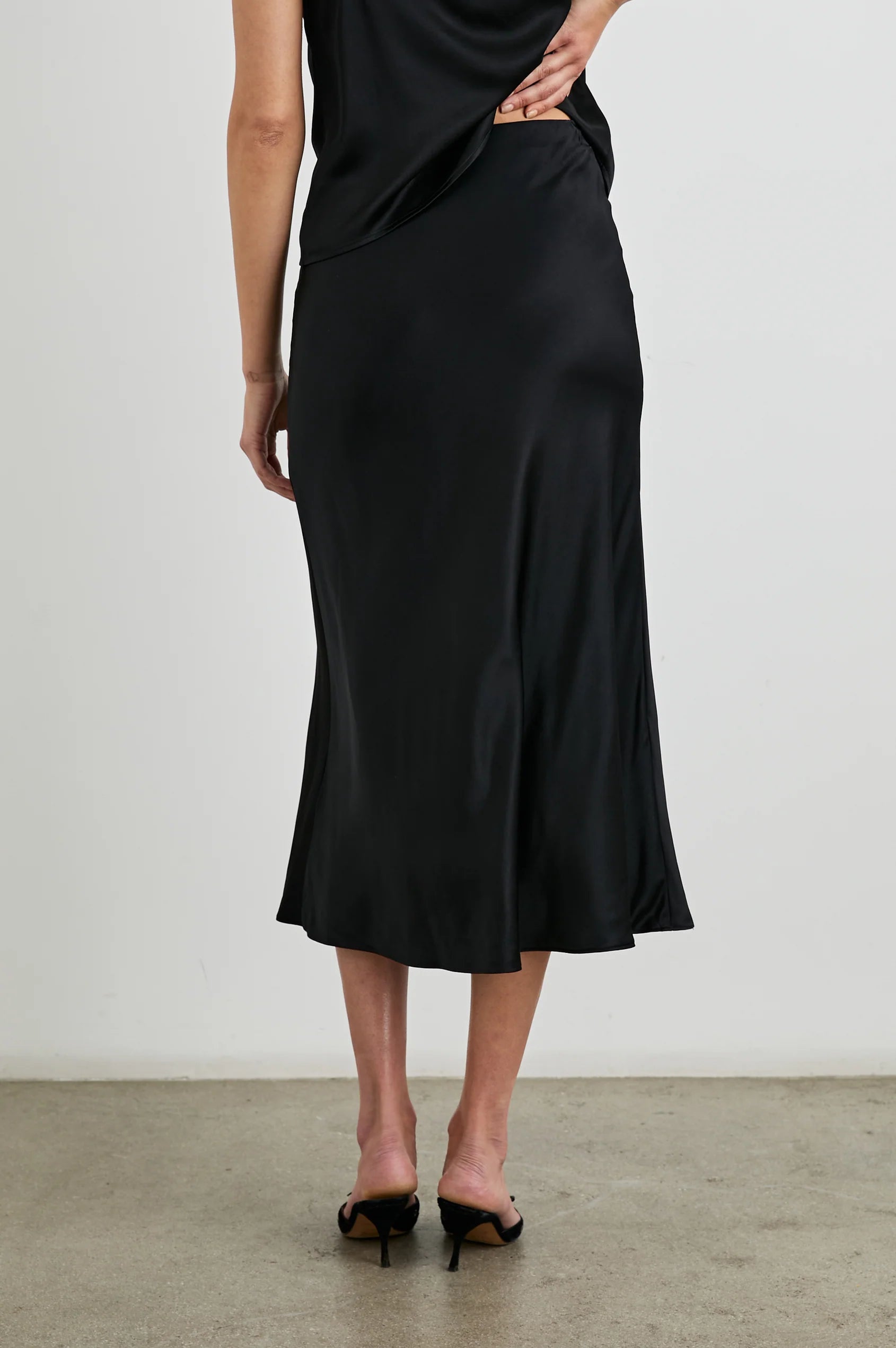 pull on bias cut satin skirt in black mid length rear view