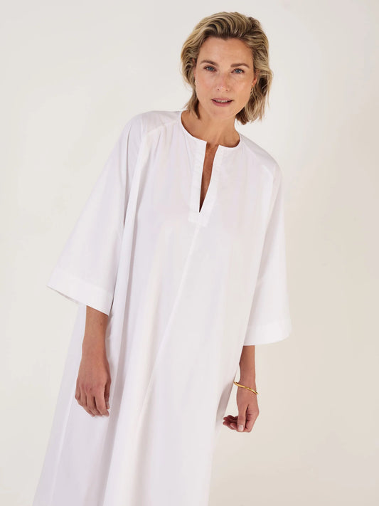 Woman wearing a white dress against a plain background worn without belt from Mondo Corsini