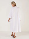 Woman wearing a white dress against a plain background rear view