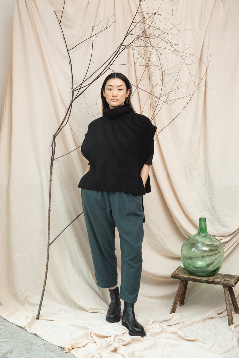 black knitted vest with rib detailing, sleeveless and roll neck model shot