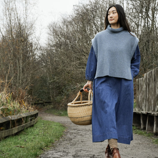 light blue knitted vest with rib detailing, sleeveless and roll neck model shot