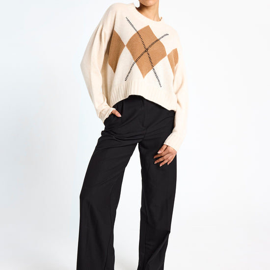 cream round neck cashmere jumper with rib detailing and tan argyle design on the front model shot
