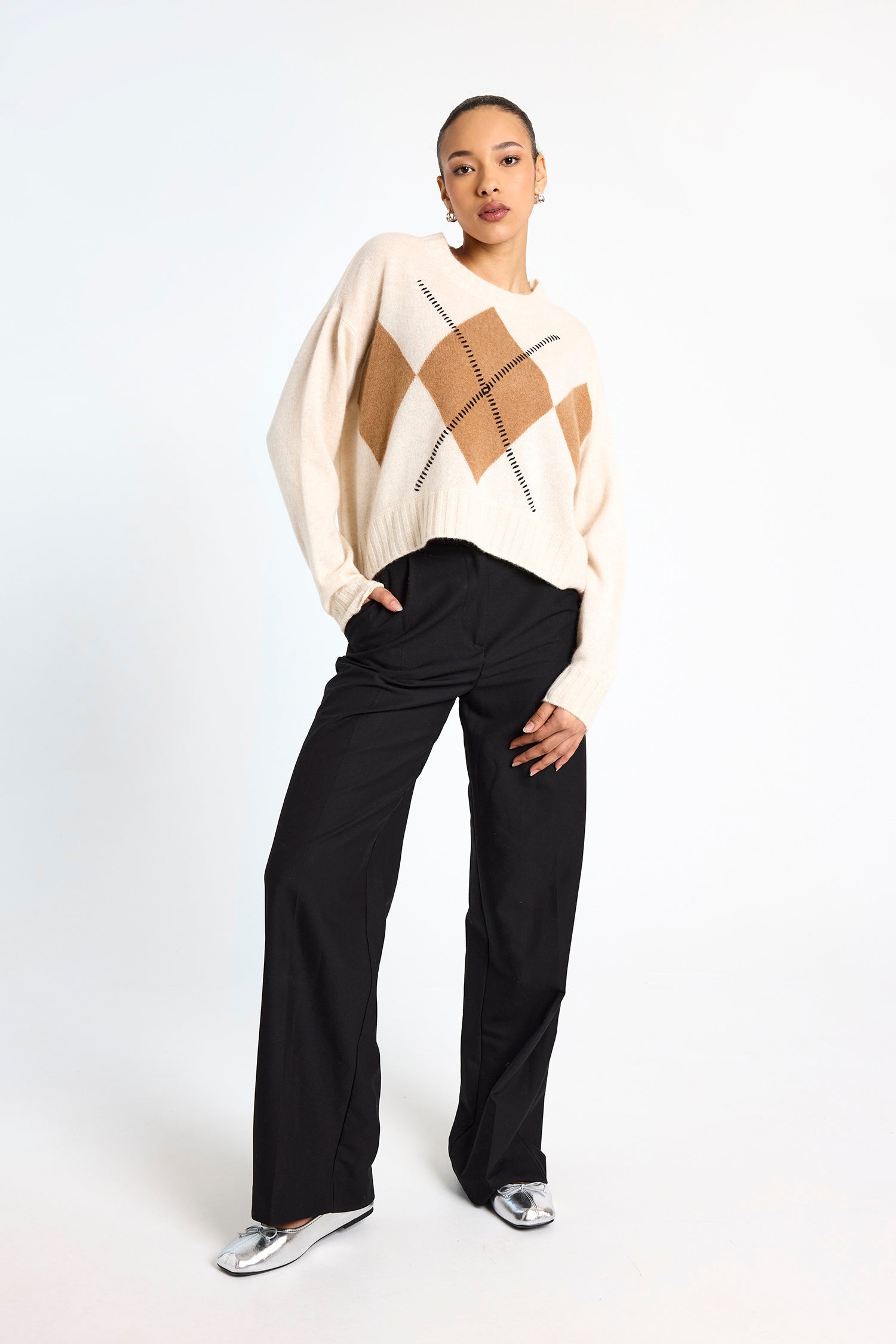 cream round neck cashmere jumper with rib detailing and tan argyle design on the front model shot