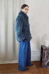 Blue faux fur short jacket worn with blue jeans side view