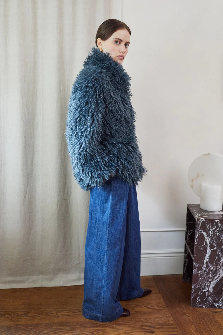 Blue faux fur short jacket worn with blue jeans side view