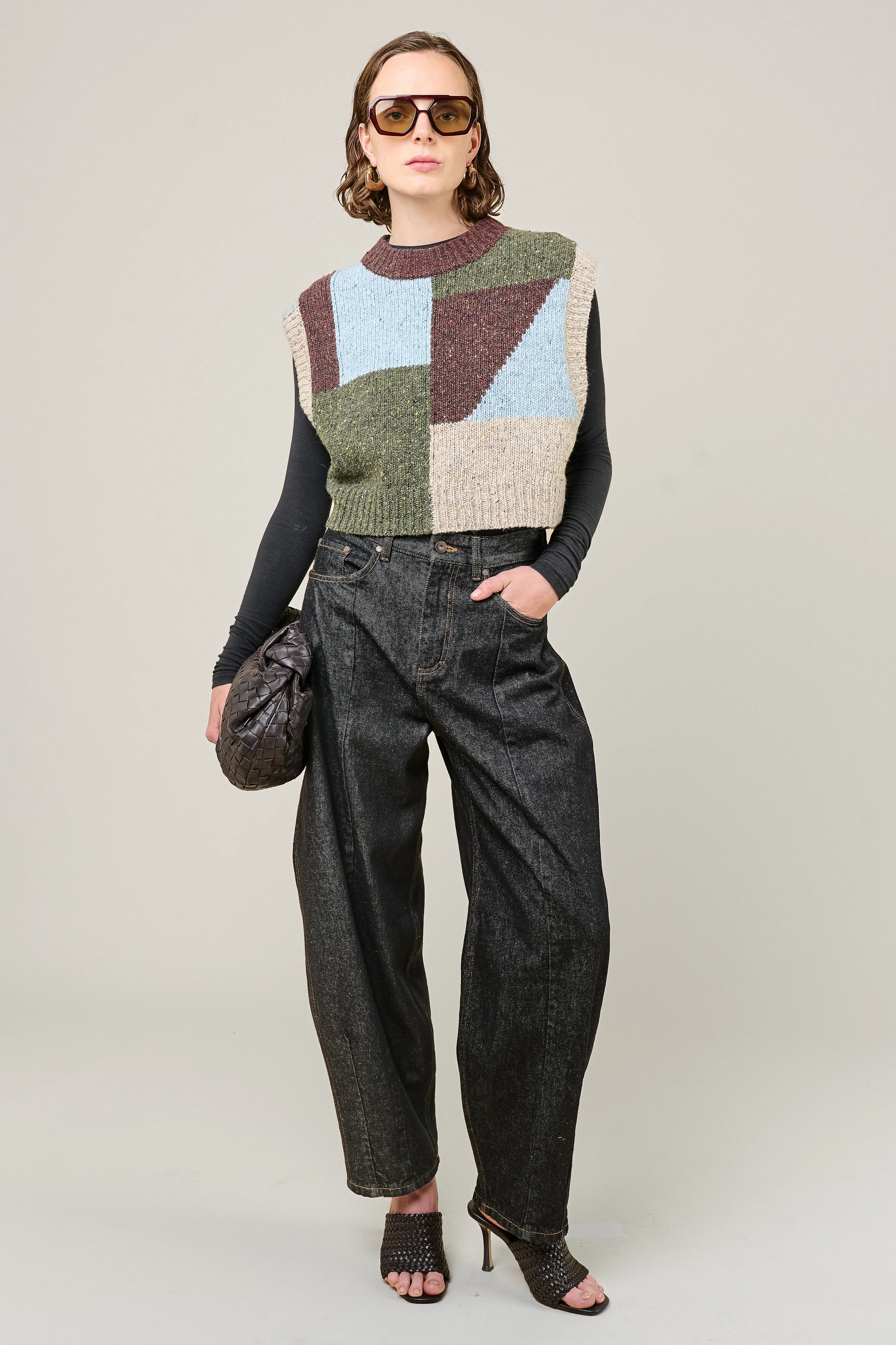 woman wearing multi colour geometric knit vest and jeans