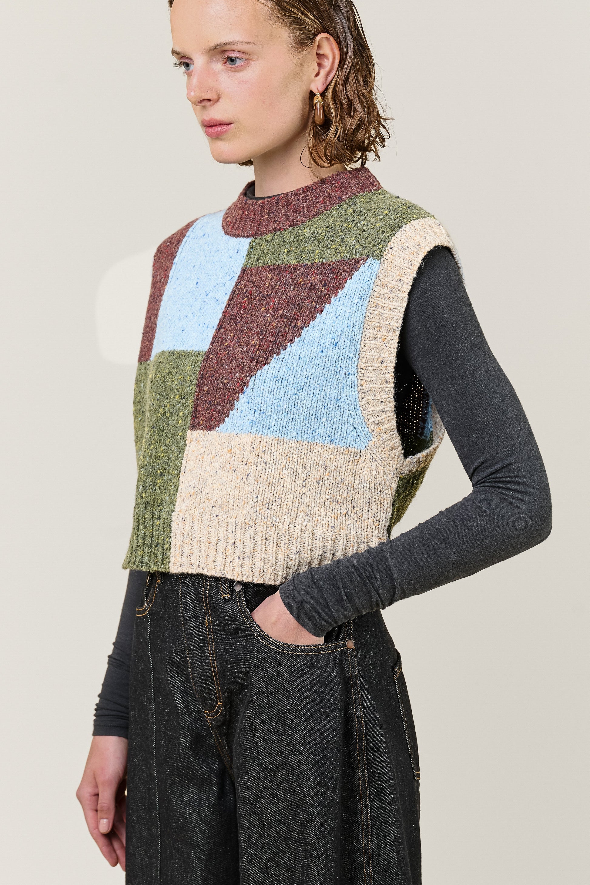 woman wearing multi colour geometric knit vest  side view