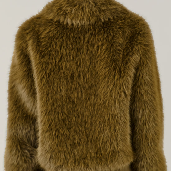 A person viewed from the back wearing a shaggy, textured olive-brown faux fur jacket and matching olive-brown trousers against a plain light gray studio background.