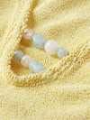 Close up detail of blue bead detail on one size yellow swimsuit from Hunza G