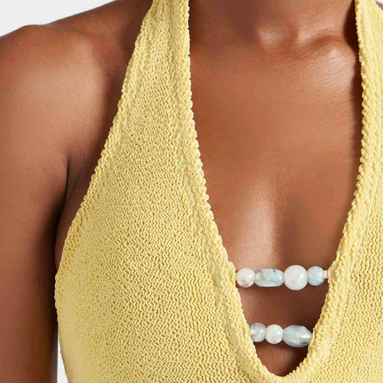 Close up neck detail of one size yellow swimsuit from Hunza G