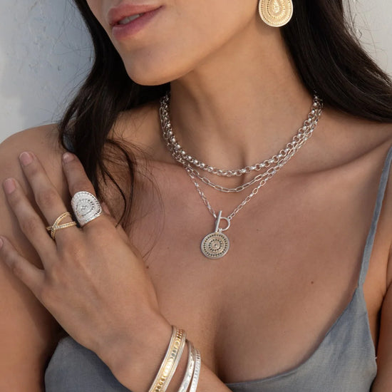 Mixed metal necklace with a coin shape pendant with balinese dot work