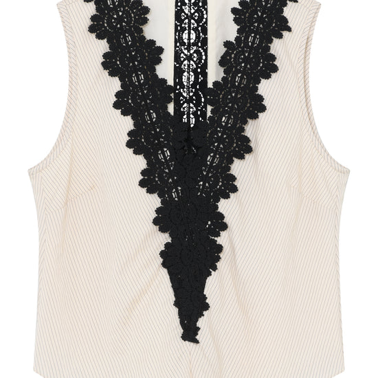 White sleeveless top with black lace detailing on a white background