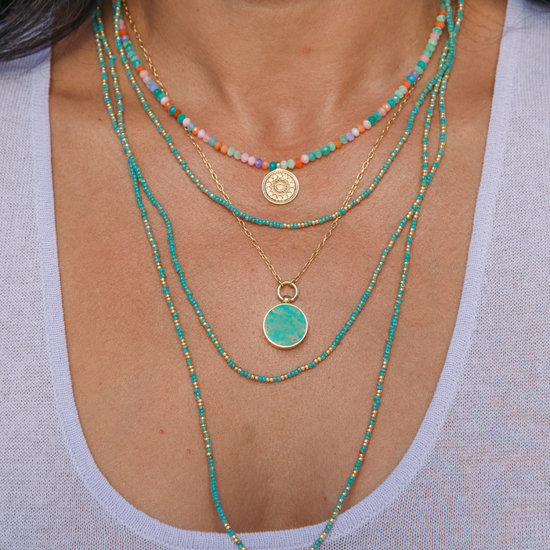 Woman wearing a stack of Anna Beck Necklaces