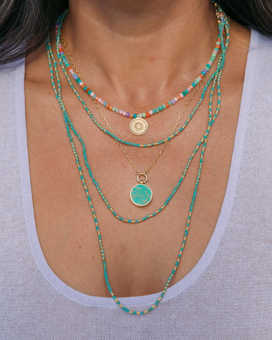 Woman wearing a stack of Anna Beck Necklaces