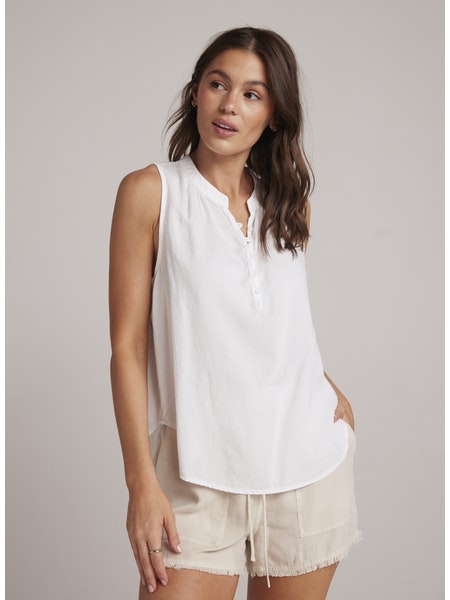 White sleeveless top with stand up collar and edge to edge button fastening along a half placket