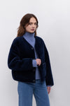 navy faux fur reversible round neck jacket with patch pockets, long sleeves, black buttons and interior dark navy faux suede with fur detailing model shot