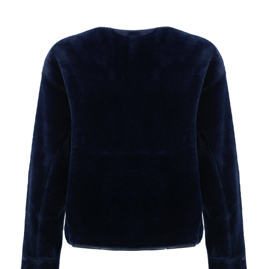 navy faux fur reversible round neck jacket with patch pockets, long sleeves, black buttons and interior dark navy faux suede with fur detailing rear view 