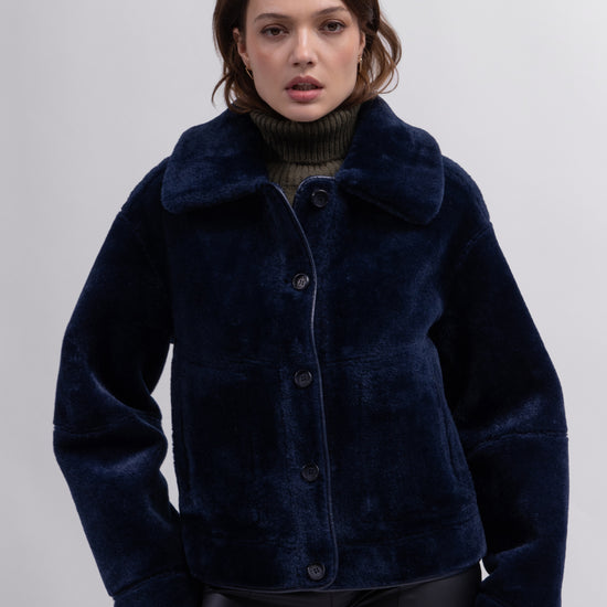 navy blue faux fur reversible short jacket with peter pan collar and side pockets model shot
