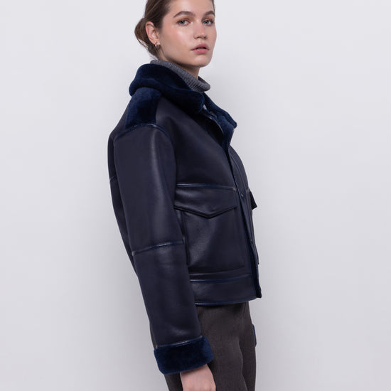navy blue faux fur reversible short jacket with peter pan collar and side pockets side view