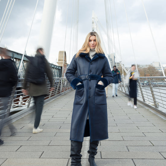 navy blue faux fur reversible coat with belt and mid length model shot