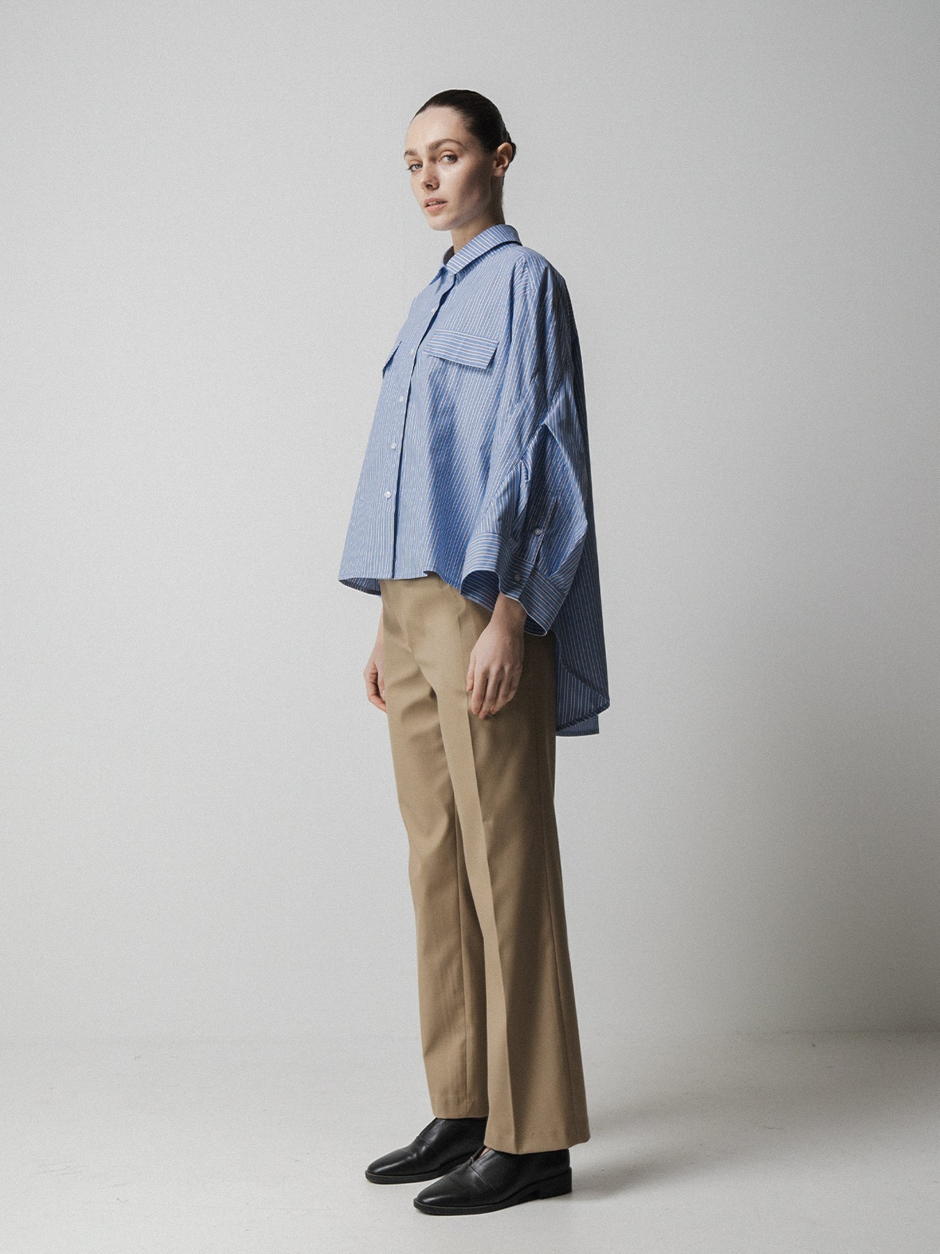 blue striped shirt with wide sleeves and dipped hem with chest pockets side view