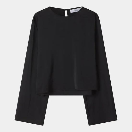 A black long-sleeve top with a unique layered, asymmetrical hem design, displayed flat against a light gray background.
