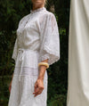 White lace dress worn by a person with a blurred background