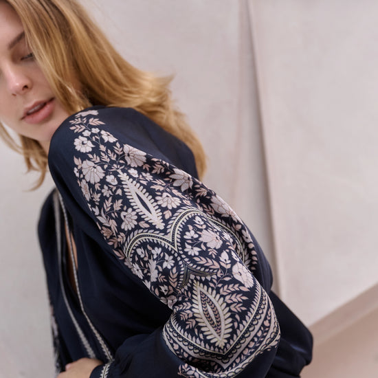 black silky blouse with paisley details and v neckline with a tie from brdr side view