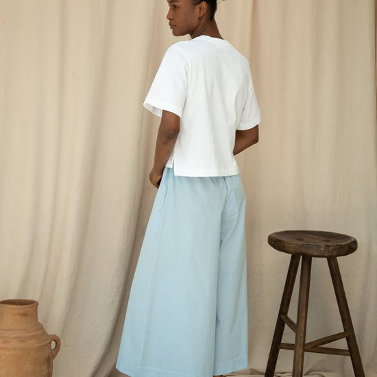 Rear view of white tee worn with wide leg trousers