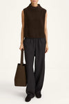 A model wearing a sleeveless dark brown knit mock-neck top and dark charcoal gray pinstriped wide-leg trousers, holding a dark brown tote bag against a clean white studio background.