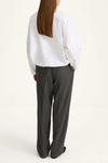 woman wearing grey trousers and white shirt rear view