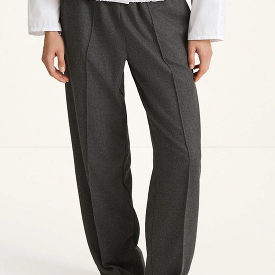 woman wearing grey trousers and white shirt rear view