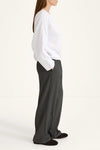 Person wearing a white shirt and gray pants on a white background