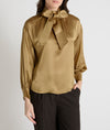 gold satin blouse with a tie bow at the neck and buttoned cuffs