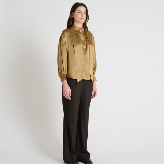 gold satin blouse with a tie bow at the neck and buttoned cuffs model shot